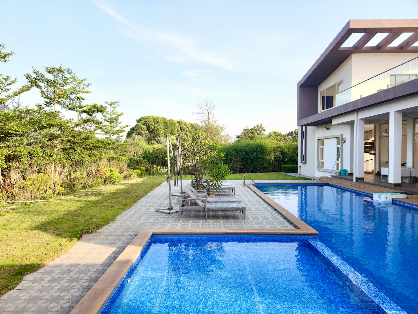 Villa moderna con piscina e giardino curato.