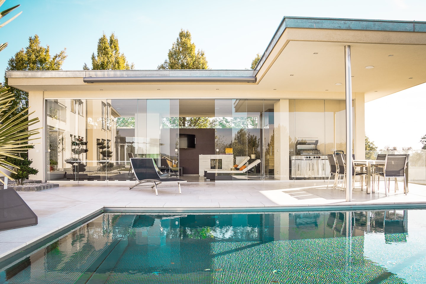 Casa moderna con piscina e cucina esterna.